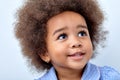 Close up portrait of little adorable African american child girl looking up, smiling Royalty Free Stock Photo