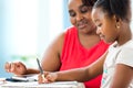 Little african girl doing home work with supervisor.