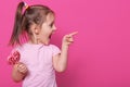 Close up portrait of little attractive child opening mouth widely, looking other side with excitement, holding heart bright