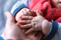 A close up portrait of little baby hands holding the hand of its father. The fingers of one hand grasp the finger of the parent Royalty Free Stock Photo