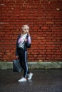 Close up portrait of little beautiful stylish kid girl near red brick wall as background Royalty Free Stock Photo