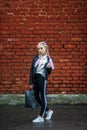 Close up portrait of little beautiful stylish kid girl near red brick wall as background Royalty Free Stock Photo