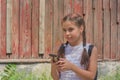 Close up portrait of little beautiful stylish kid girl near red wall as background Royalty Free Stock Photo