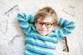 Close-up portrait of little blond kid boy with brown eyeglasses Royalty Free Stock Photo