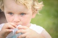 Close up portrait of little blue eyed boy sucking on his shirt Royalty Free Stock Photo