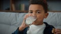 Close up portrait little funny cute kid boy ethnic child drink milk with cookies at home looking to camera. African Royalty Free Stock Photo