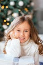 Close-up portrait of a little girl with big eyes and a wide sincere cute smile during the New Year holidays, the concept