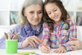 Close up portrait of little girl drawing with her grandmother Royalty Free Stock Photo