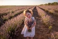 Close-up portrait of little girl in flower dress holding bouquet with purple lavender at sunset Royalty Free Stock Photo