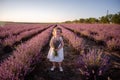 Close-up portrait of little girl in flower dress holding bouquet with purple lavender at sunset Royalty Free Stock Photo