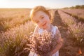 Close-up portrait of little girl in flower dress holding bouquet with purple lavender at sunset Royalty Free Stock Photo