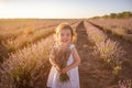 Close-up portrait of little girl in flower dress holding bouquet with purple lavender at sunset Royalty Free Stock Photo