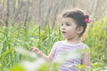 Close-up portrait of a little girl at garden- green field at spring season Royalty Free Stock Photo