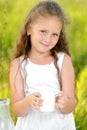 Close up portrait little girl holding glass of milk outdoor summer Royalty Free Stock Photo