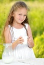Close up portrait little girl holding glass of milk outdoor summer Royalty Free Stock Photo