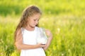Close up portrait little girl holding pitcher of milk outdoor summer Royalty Free Stock Photo