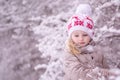 Close-up portrait of a little girl in a white christmas hat on a background of a snow park .Copy space Royalty Free Stock Photo