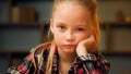 Close up portrait little offended child sad upset bored preschool girl pretty blonde female kid look at camera sit at Royalty Free Stock Photo