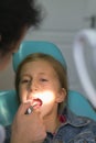 Close up portrait of a little smiling girl at dentist office. Dentist examining little girl's teeth in clinic. people, medicine,