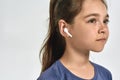 Close up portrait of little sportive girl child wearing earphones, listening to music, looking away while posing Royalty Free Stock Photo