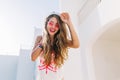 Close-up portrait of long-haired girl walking down the street of exotic town after resting on beach. Adorable smiling Royalty Free Stock Photo