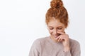 Close-up portrait lovely, coquettish and elegant redhead woman showing sensuality, comb hair in messy bun, look down