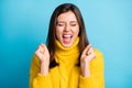 Close-up portrait of lovely ecstatic cheerful lucky girl fan holding fists isolated over bright blue color background