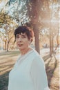 Close up portrait of a hispanic senior woman in the park at sunset Royalty Free Stock Photo