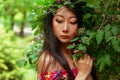 Portrait of a lovely mysterious asian girl with green leaves. Beauty, cosmetics.