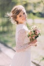 Close up portrait of magical beautiful young bride wearing elegant white dress with bouquet in the park. Royalty Free Stock Photo