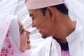 Close up portrait of a malay bride and groom under veil with lovely emotion.