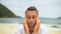 Close-up portrait man apply sun cream protection lotion, looking at camera. Funny man on beach near sea smearing Royalty Free Stock Photo