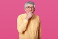 Close up portrait of man with black rounded glasses, dressed yellow shirt and bow tie. Eldery senior with wide opened eyes, has Royalty Free Stock Photo