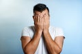 Close-up portrait of a man, covering his face with his hands. On a light background. The concept of body language Royalty Free Stock Photo