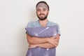 Close up portrait of man dressed gray casual t shirt ready to go to bed, white wall on background. Guy with happy face holds Royalty Free Stock Photo