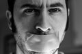 Close up portrait of a man with duct tape over his mouth Royalty Free Stock Photo