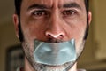 Close up portrait of a man with duct tape over his mouth Royalty Free Stock Photo