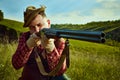 Close up portrait with man, hunter wearing vintage clothes and checked shirt shooting prey with a rifle over marvelous Royalty Free Stock Photo