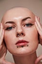 Masculine bald woman with piercing at her face