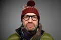 Close up portrait of middle aged europeam man in funny warm hat and glasses noticing hidden camera. Royalty Free Stock Photo