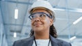 Close Up Portrait of a Middle Aged, Happy Black Female Engineer Putting On a White Hard Hat, While