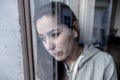 Middle aged latin woman sad and depressed looking through the window refection in depression concept Royalty Free Stock Photo