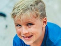 Close up portrait mischievous cute blond side looking blue eyed boy making freckles face play laughing in happy mood