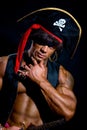 Close-up portrait muscular pirate in the studio on a dark background