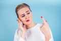 Close-up portrait of nervous unhappy young blonde woman looking at a broken fingernail and crying . red long nails Royalty Free Stock Photo
