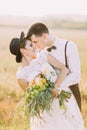 The close-up portrait of the newlyweds standing head-to-head to each other while the grooms is hugging the bride back Royalty Free Stock Photo