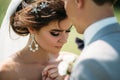 Close-up portrait of newlyweds on wedding day. The bride hugs with the groom before the kiss. Man in business suit and