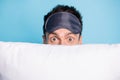 Close-up portrait of nice funny amazed guy hiding behind soft pillow having fun spy pry isolated over bright blue color Royalty Free Stock Photo