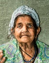 Close up portrait of old homeless Gypsy beggar woman with wrinkled face skin begging for money on the street in the city and looki Royalty Free Stock Photo