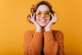 Close-up portrait of pale caucasian girl with beautiful smile. Photo of relaxed european woman wears round yellow